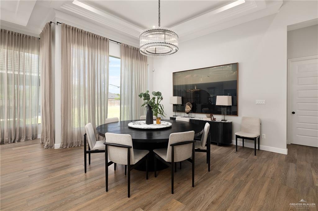 1803 Melissa Rae Drive Mission, TX 78572 - Photo 4 of 31 Dining space featuring a raised ceiling, a chandelier, and wood finished floors