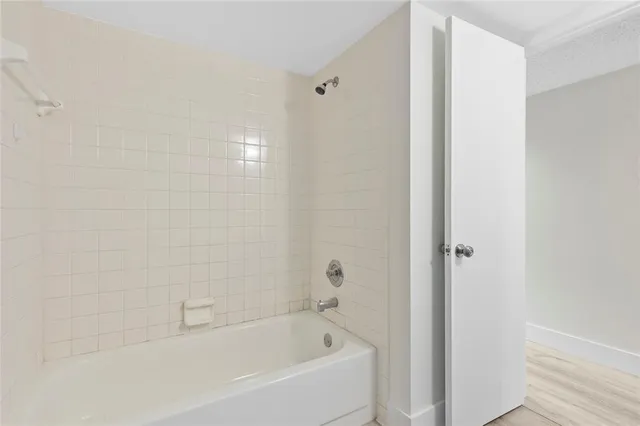 a white bath tub sitting next to a white wooden wall
