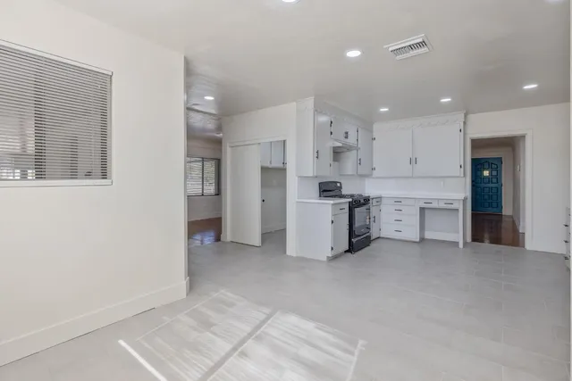 a kitchen with stainless steel appliances granite countertop a white stove top oven and white cabinets