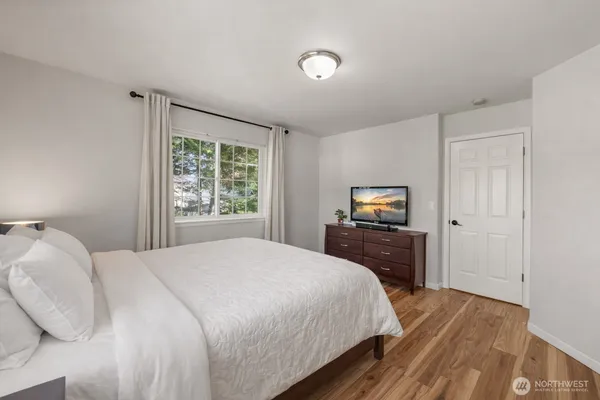 a bedroom with a bed and wooden floor