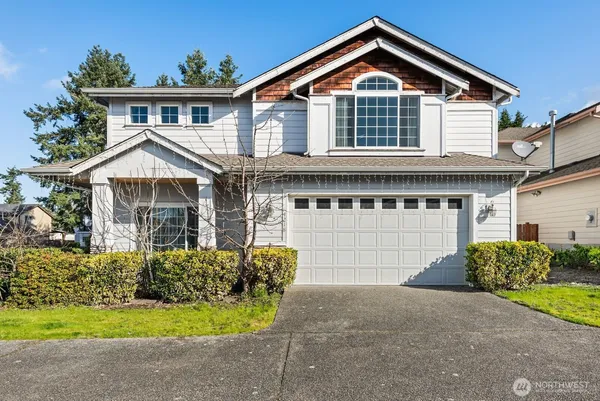 a front view of a house with a yard and garage