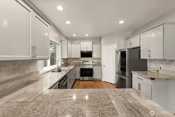 a large kitchen with a stove a sink and a refrigerator