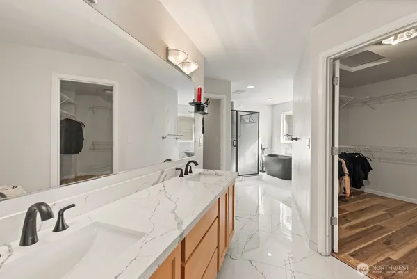 a spacious bathroom with a tub sink and mirror