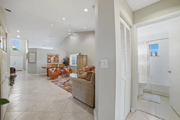 a living room with furniture a mirror and a glass door