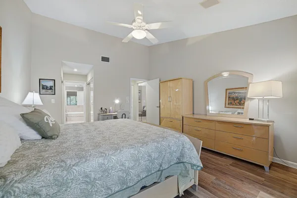 a spacious bedroom with a large bed and a chandelier