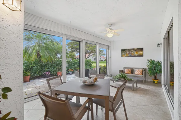 a dining room with furniture a large window and potted plants