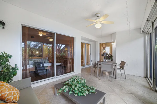a view of a dining room with furniture a chandelier and window