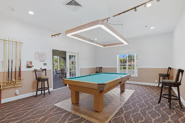 a room with pool table and windows