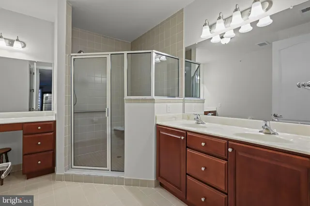 a bathroom with a granite countertop sink a light fixture and a mirror