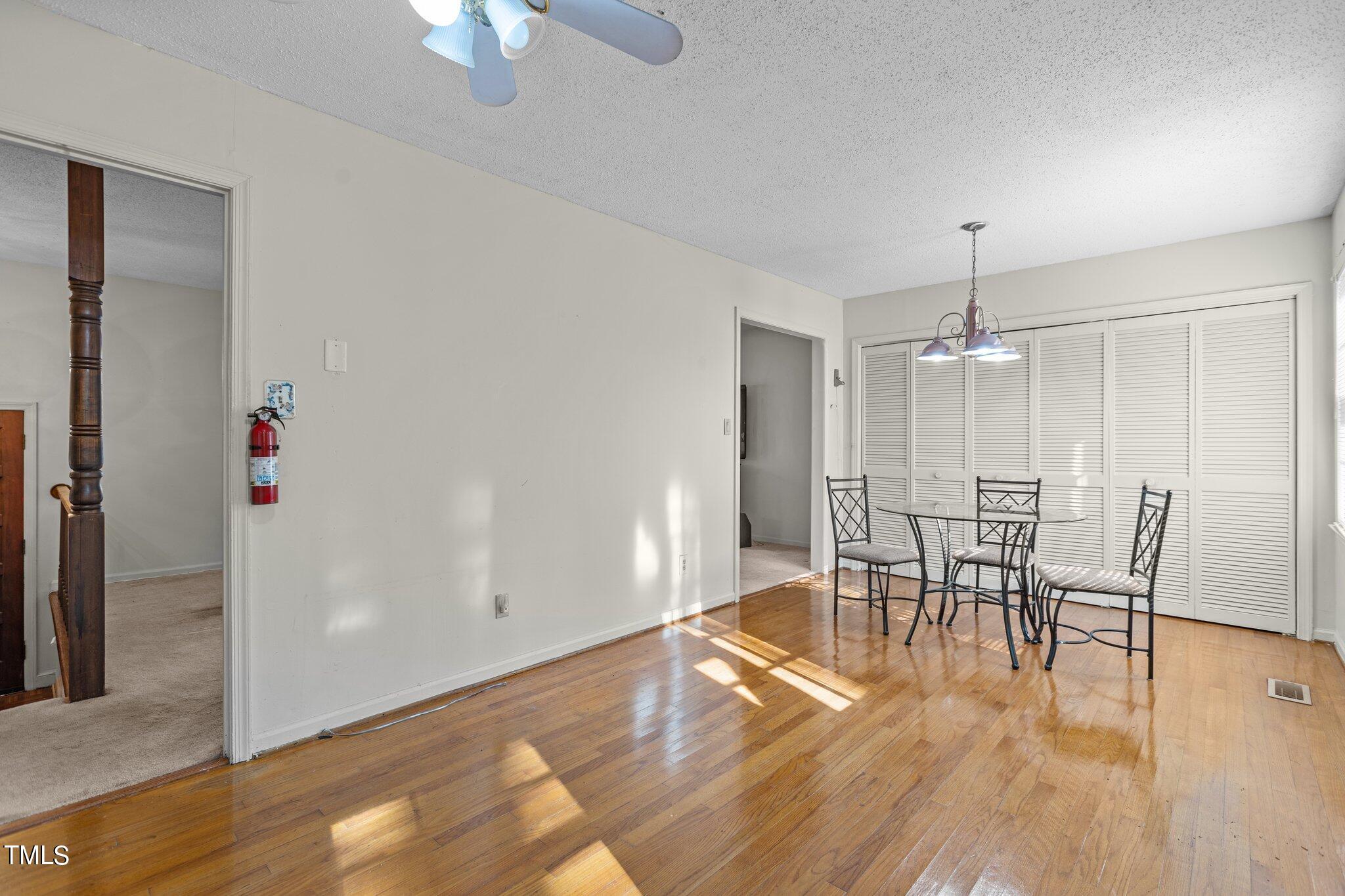1500 Princess Anne Road Raleigh, NC 27607 - Photo 12 of 37 a dining room with wooden floor a chandelier a glass table and chairs