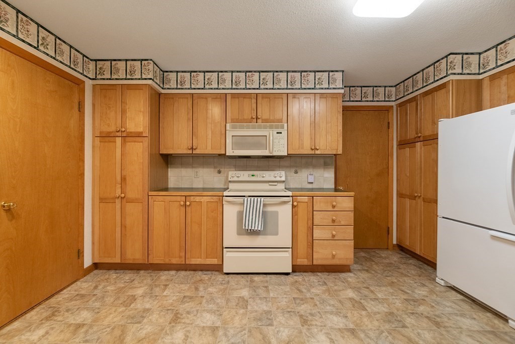 83 Redfern Drive Longmeadow, MA 01106 - Photo 11 of 40 a kitchen with white cabinets and white appliances