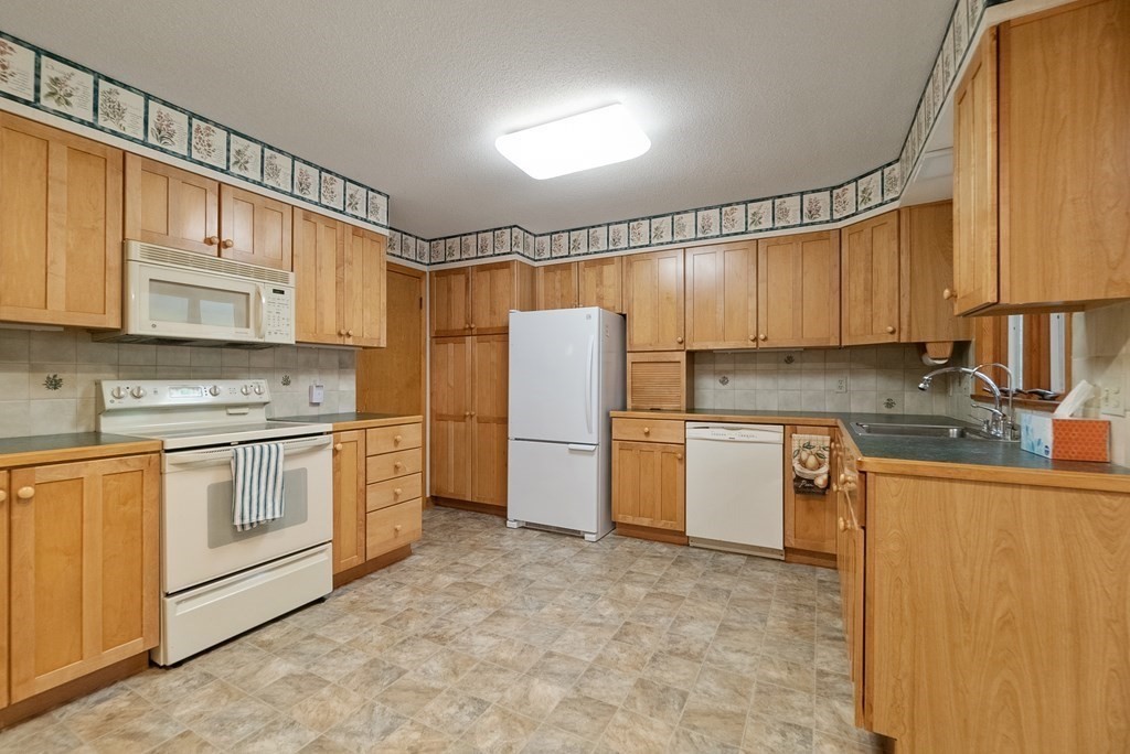 83 Redfern Drive Longmeadow, MA 01106 - Photo 10 of 40 a kitchen with stainless steel appliances granite countertop a refrigerator sink and cabinets