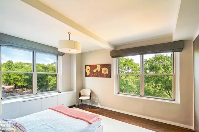 a bedroom with a bed and a large window