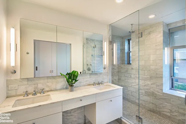 a bathroom with a double vanity sink mirror and shower