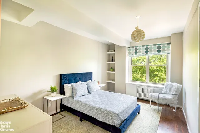 a bedroom with furniture and a large window