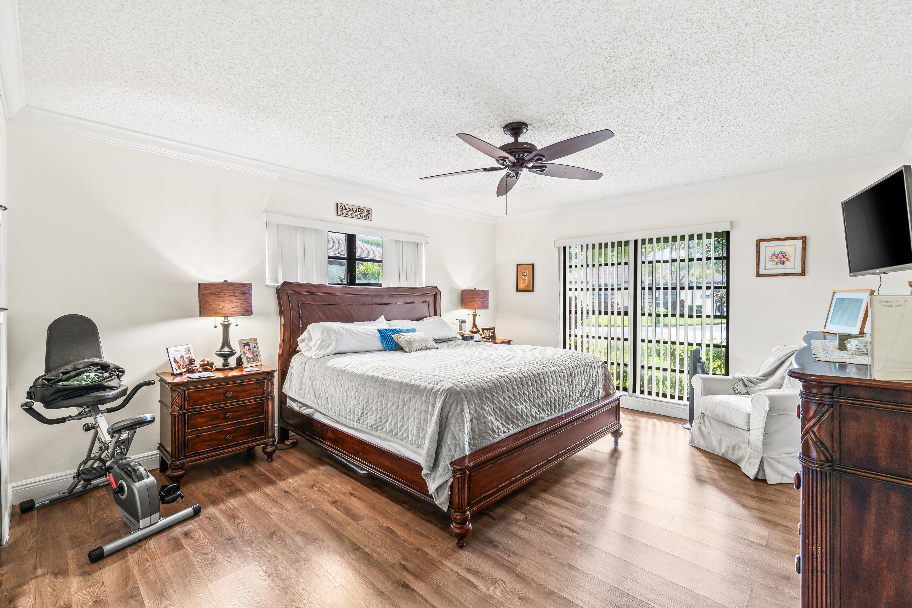 4863 Hawkwood Road, Unit B Boynton Beach, FL 33436 - Photo 12 of 23 a bedroom with a bed a large window and a flat screen tv