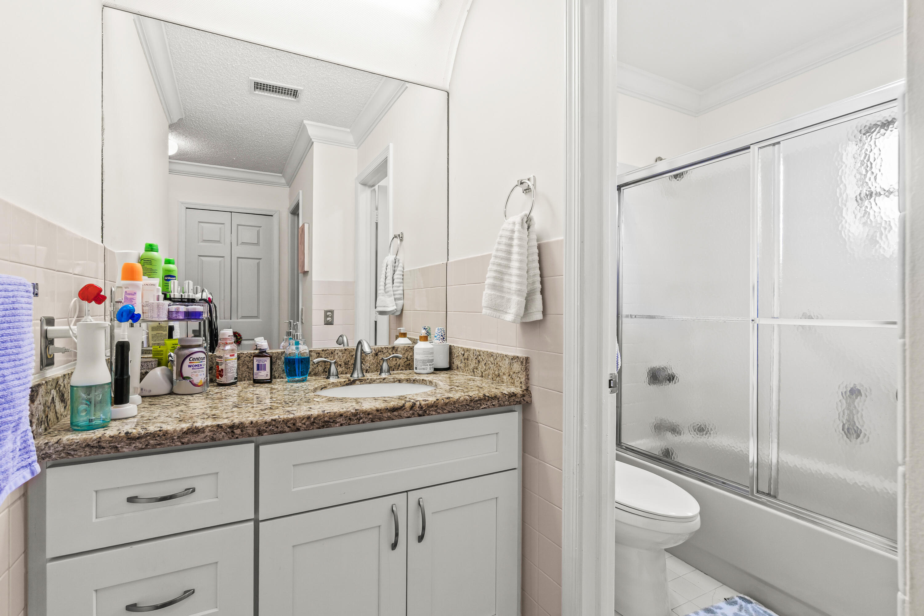 4863 Hawkwood Road, Unit B Boynton Beach, FL 33436 - Photo 14 of 23 a bathroom with a granite countertop sink a toilet and a shower