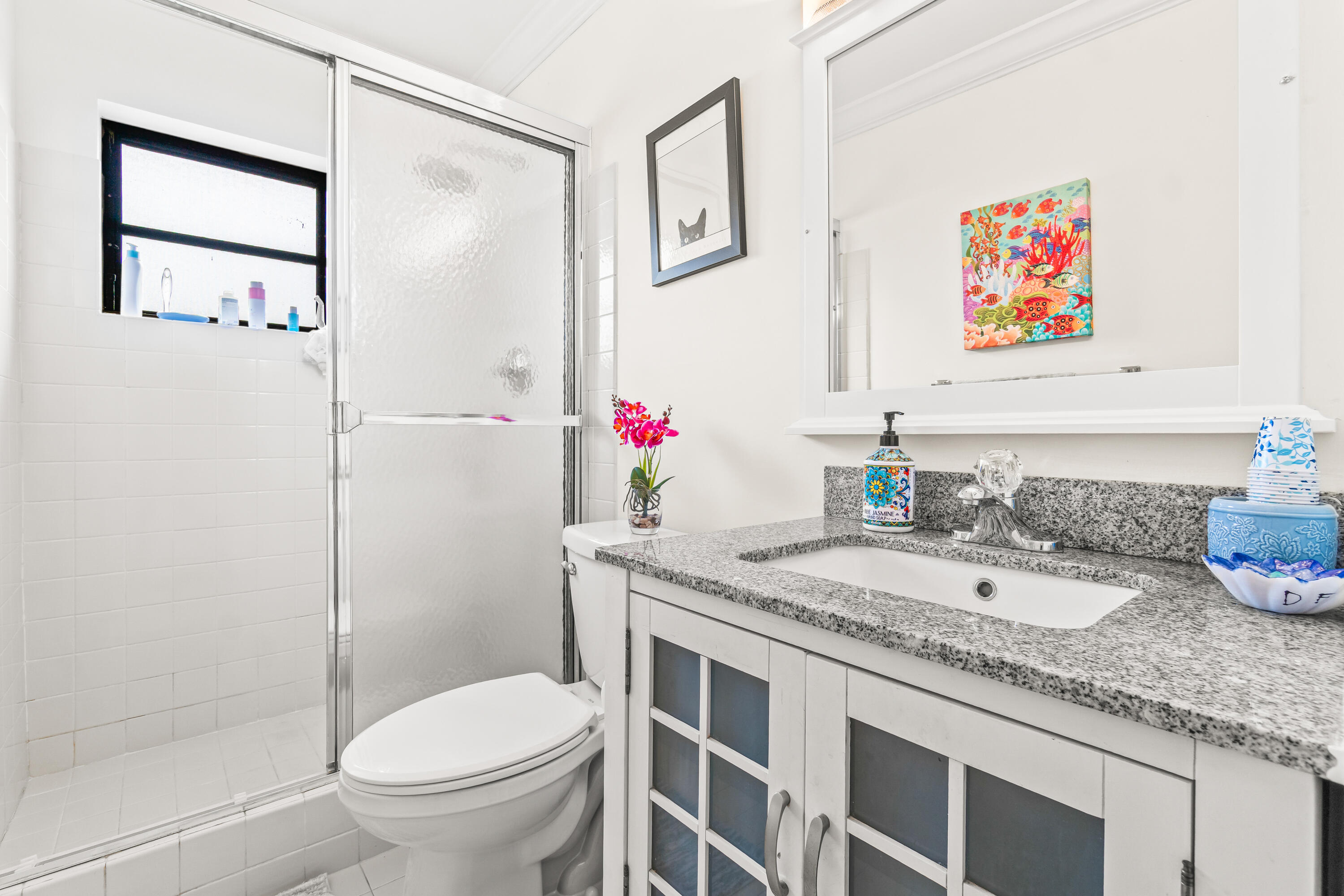 4863 Hawkwood Road, Unit B Boynton Beach, FL 33436 - Photo 17 of 23 a bathroom with a granite countertop sink mirror vanity and toilet