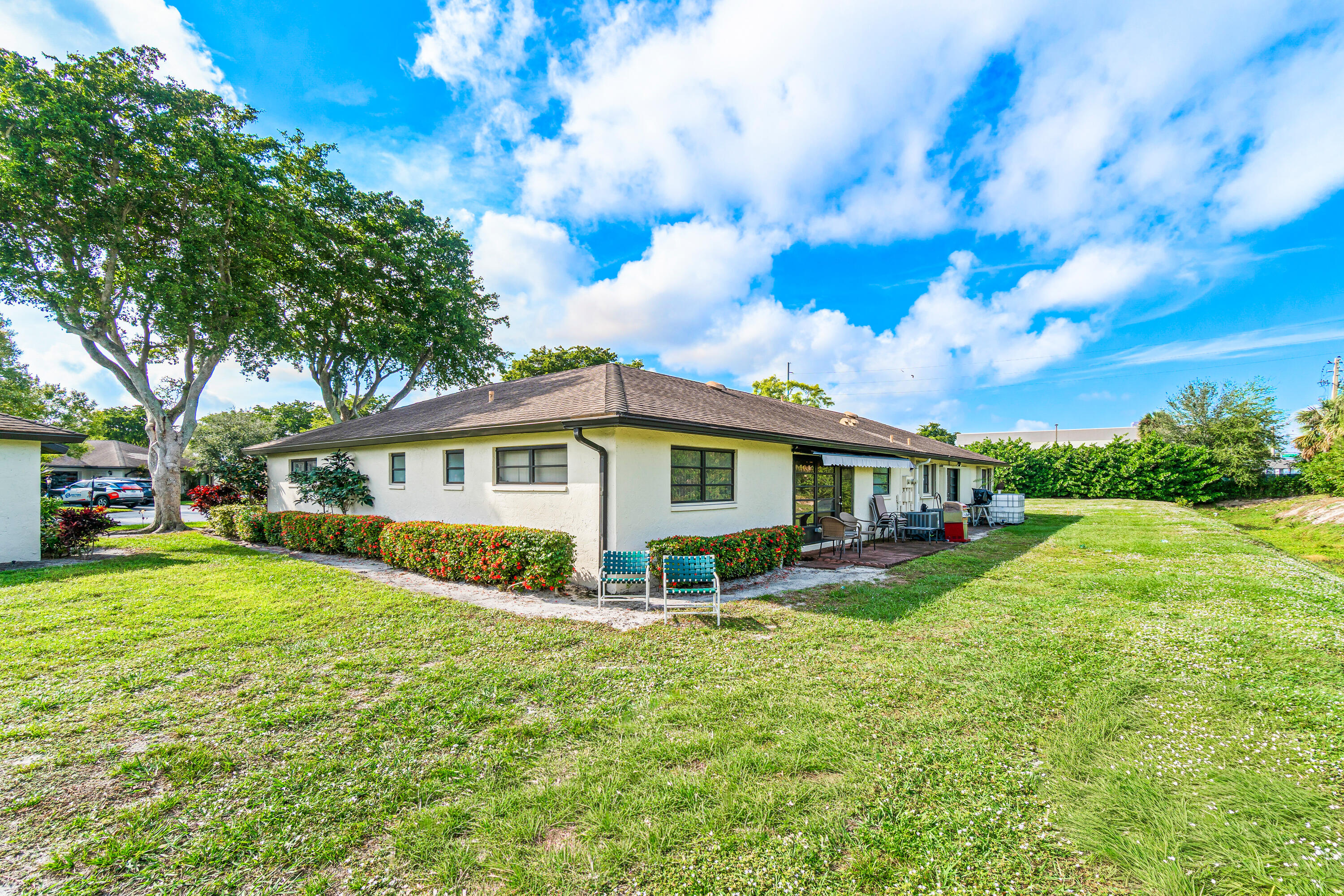 4863 Hawkwood Road, Unit B Boynton Beach, FL 33436 - Photo 21 of 23 a view of a house with a big yard and large trees