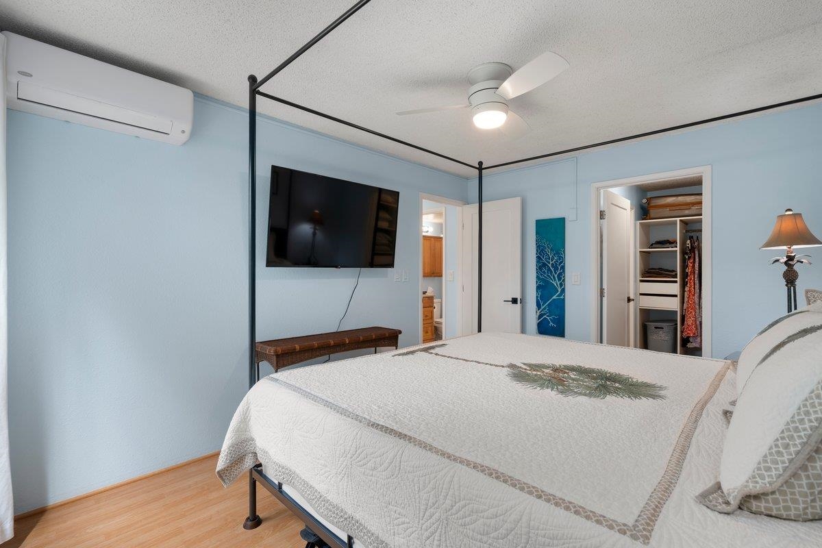 140 Uwapo Road, Unit 35102 Kihei, HI 96753 - Photo 17 of 30 a bedroom with a bed and a flat screen tv