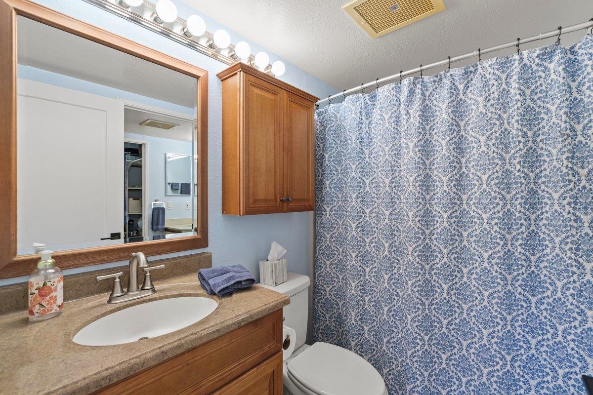 140 Uwapo Road, Unit 35102 Kihei, HI 96753 - Photo 23 of 30 a bathroom with a granite countertop sink mirror vanity and toilet