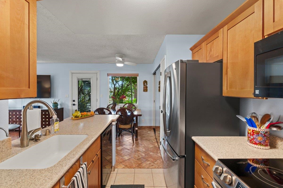140 Uwapo Road, Unit 35102 Kihei, HI 96753 - Photo 27 of 30 a kitchen with kitchen island granite countertop a sink stove and refrigerator