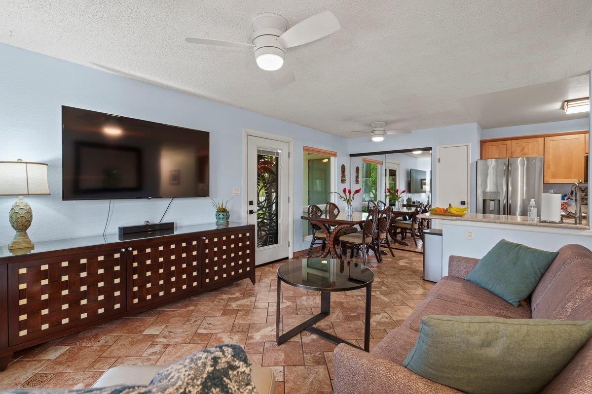 140 Uwapo Road, Unit 35102 Kihei, HI 96753 - Photo 3 of 30 a living room with furniture a flat screen tv and a large window