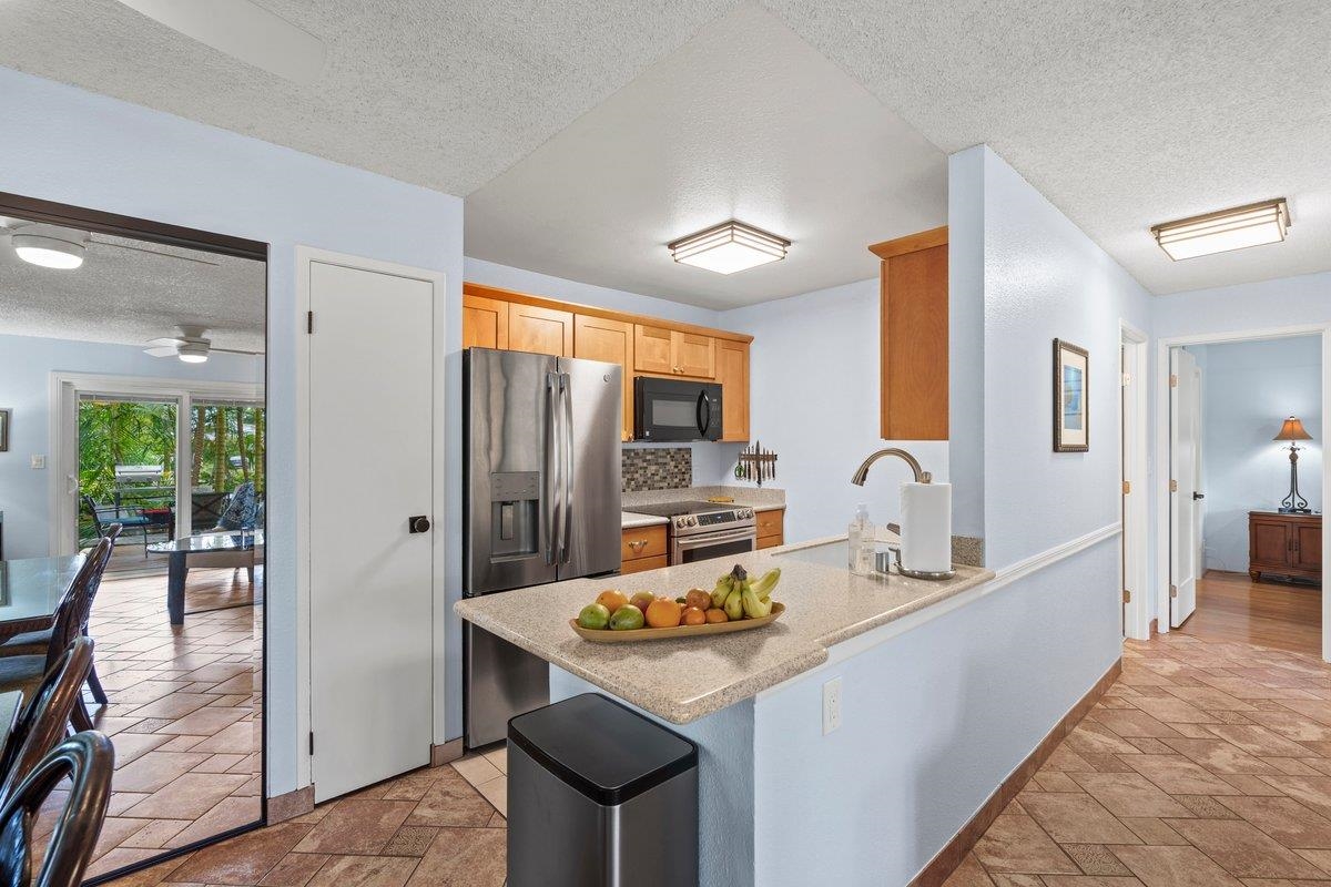 140 Uwapo Road, Unit 35102 Kihei, HI 96753 - Photo 5 of 30 a kitchen with granite countertop a sink stove and refrigerator