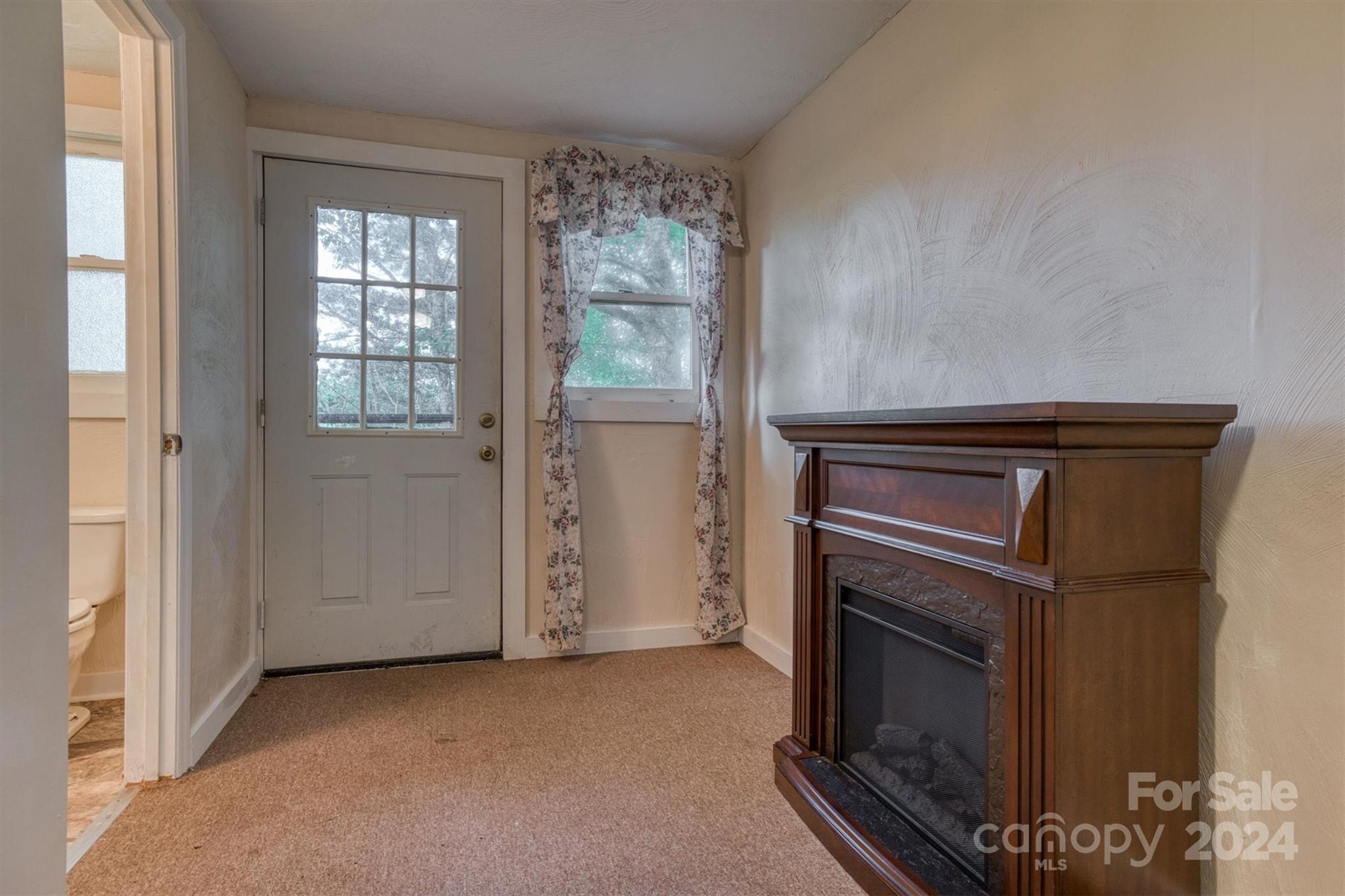 455 Hemlock Hill Road Boone, NC 28607 - Photo 23 of 37 a view of an empty room with a fireplace and a window