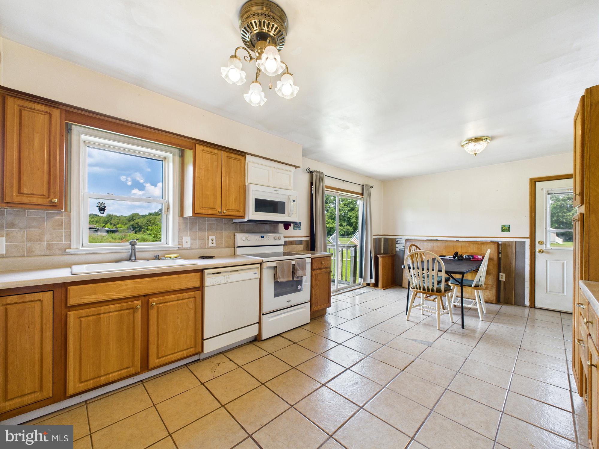 12502 Woodbridge Road Greenwood, DE 19950 - Photo 8 of 38 a kitchen with a sink dining table and chairs