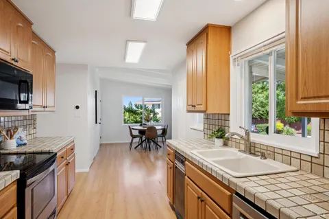a kitchen with granite countertop a sink stove and cabinets