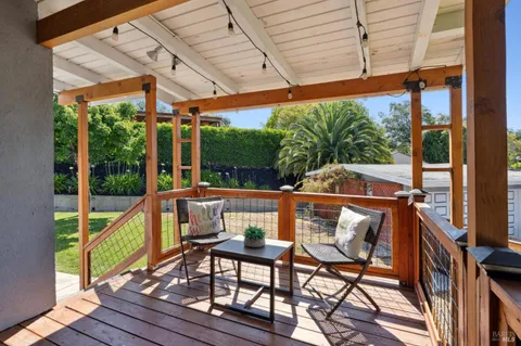 a view of porch with a table and chairs