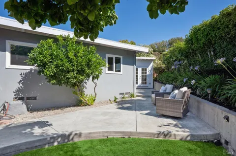a view of a big house with a big yard plants and large trees