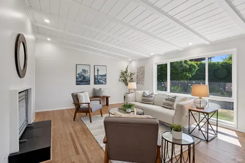 a living room with furniture a table and a large window