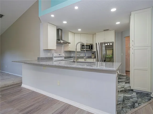 a view of kitchen with center island wooden floor and living room view