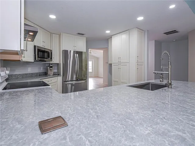 a kitchen with stainless steel appliances a refrigerator and a stove top oven