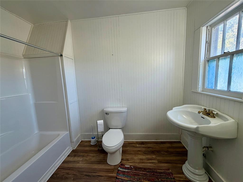 600 Mercer Street Quanah, TX 79252 - Photo 10 of 28 a bathroom with a sink toilet and a bathtub