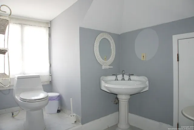 a bathroom with a sink a toilet and a mirror