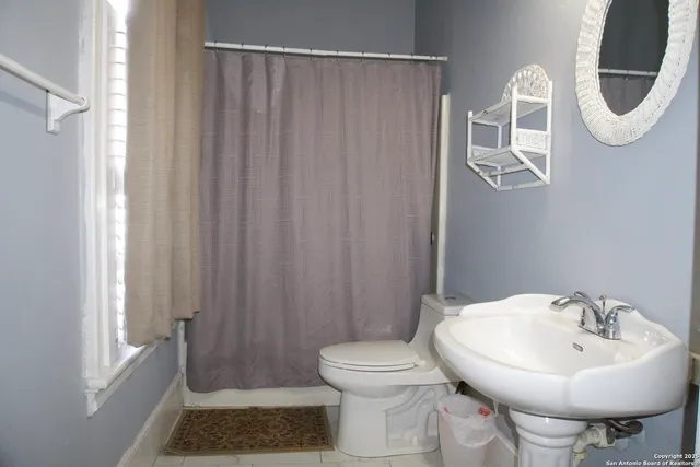 a bathroom with a sink a toilet and a mirror