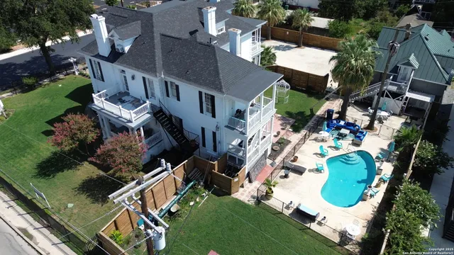 an aerial view of a house with a swimming pool and outdoor seating
