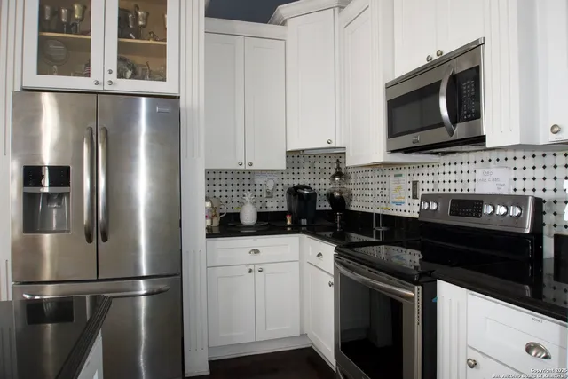 a kitchen with stainless steel appliances kitchen island granite countertop a stove microwave and refrigerator