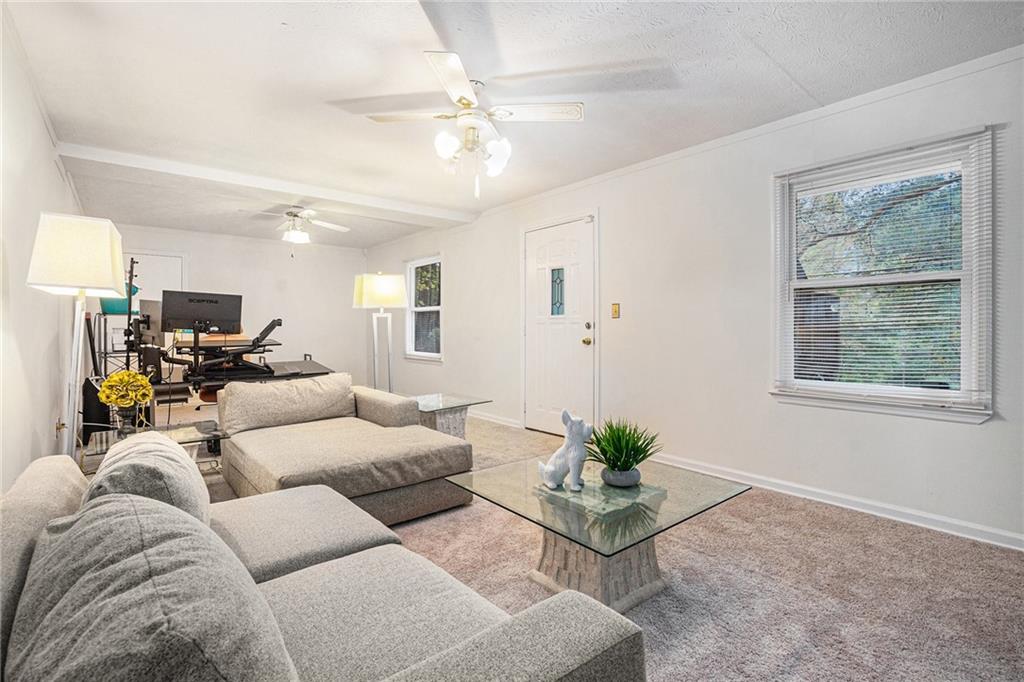 1883 Suwanee Terrace Northwest Suwanee, GA 30024 - Photo 16 of 25 a living room with furniture and a chandelier