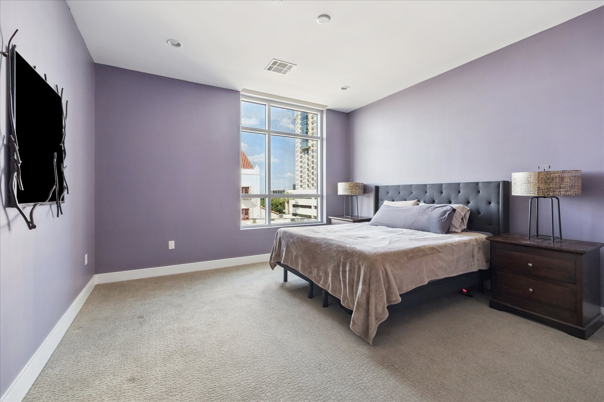3331 D'Amico Street, Unit 404 Houston, TX 77019 - Photo 12 of 22 a bedroom with a bed and a flat tv screen on dresser