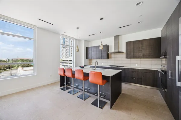 a kitchen with a table chairs refrigerator and microwave