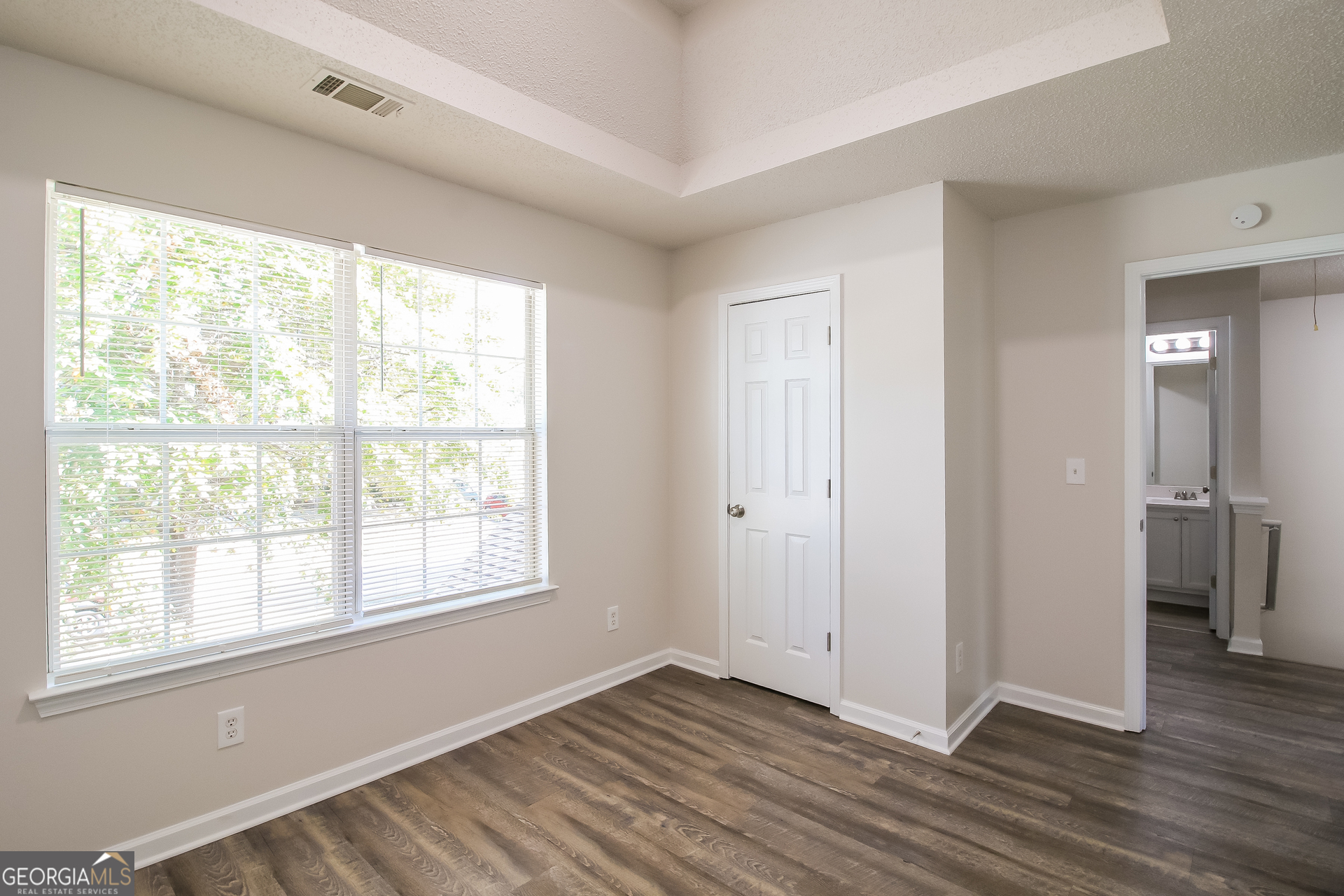 225 Colser Drive Covington, GA 30016 - Photo 11 of 17 a view of an empty room with wooden floor and a window