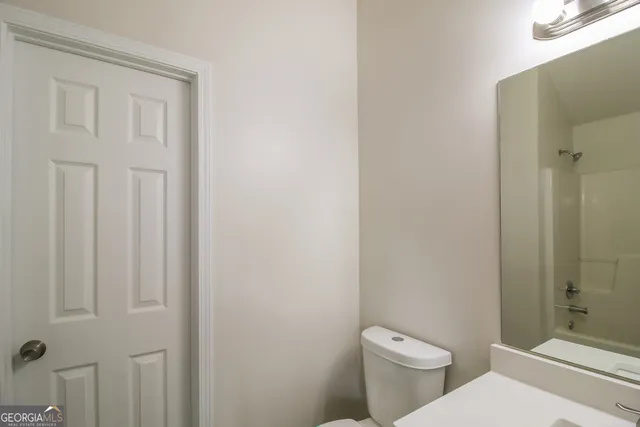 a white toilet sitting next to a bathroom sink