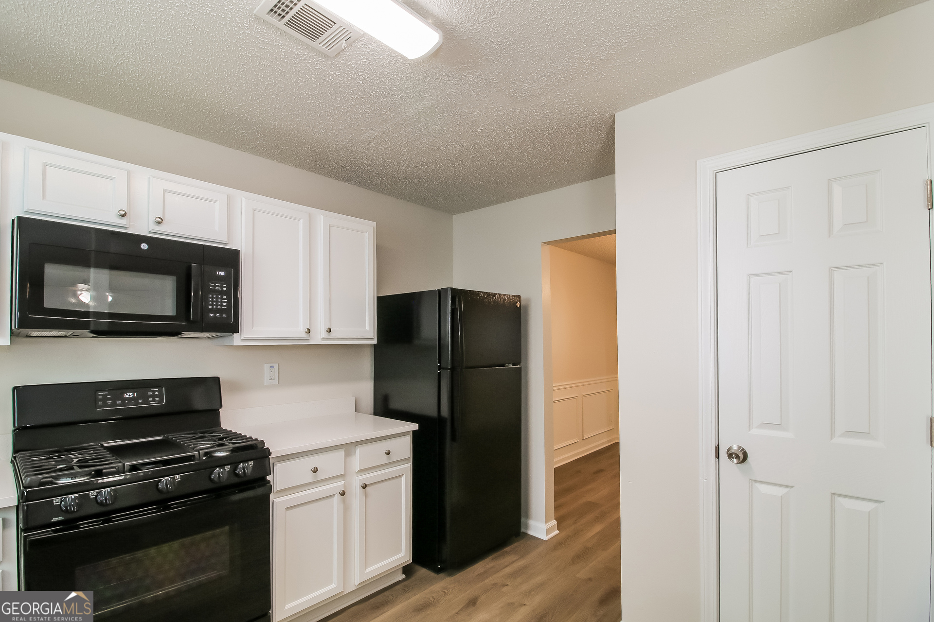 225 Colser Drive Covington, GA 30016 - Photo 6 of 17 a kitchen with a refrigerator stove and microwave
