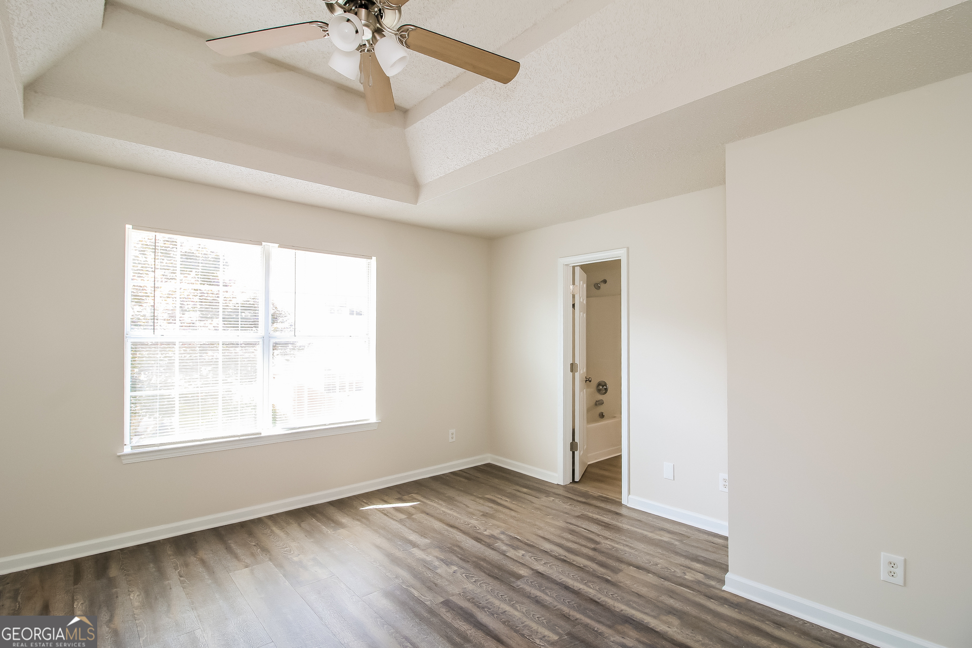 225 Colser Drive Covington, GA 30016 - Photo 8 of 17 a view of an empty room with a window and wooden floor