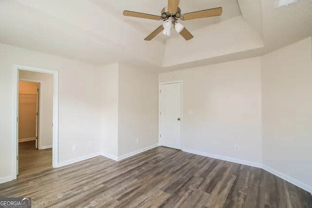 a view of a room with wooden floor and ceiling fan