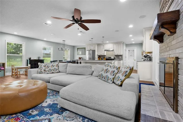 a living room with furniture kitchen view and a window